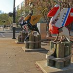 colorful pelican statues lined up on a sidewalk