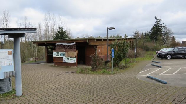 Walkways, buildings with restrooms, signage, and part of parking lot showing no steps or other barriers to trailhead.